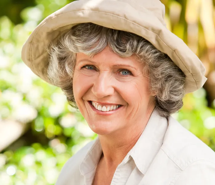 senior woman looking at the camera and smiling in her garden